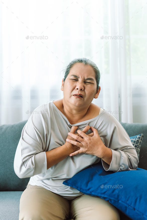 Senior asian woman has chest pain. Elderly woman has heart disease. Emergency signs of heart